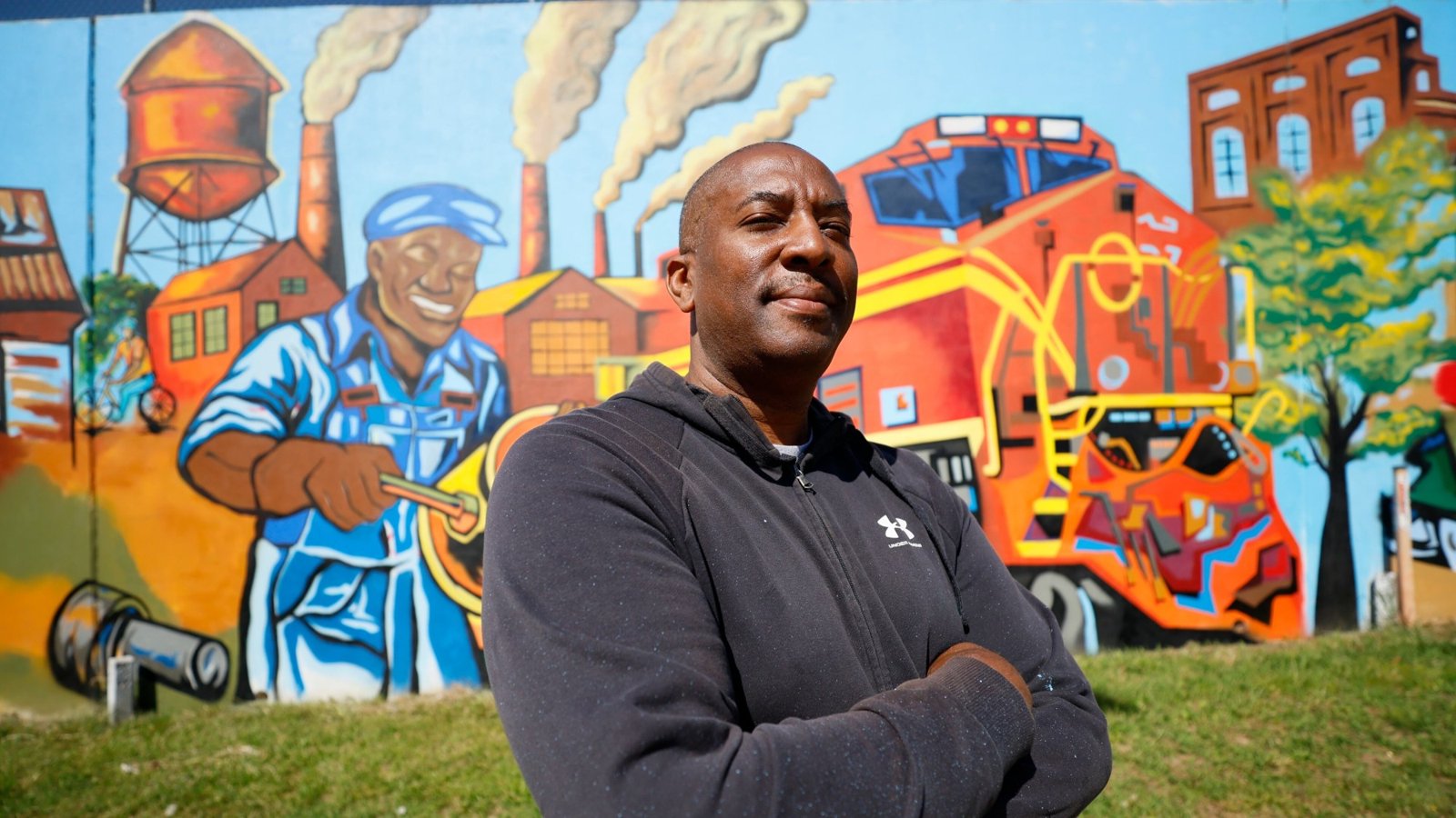 Corey Barksdale standing in front of one of his colorful murals